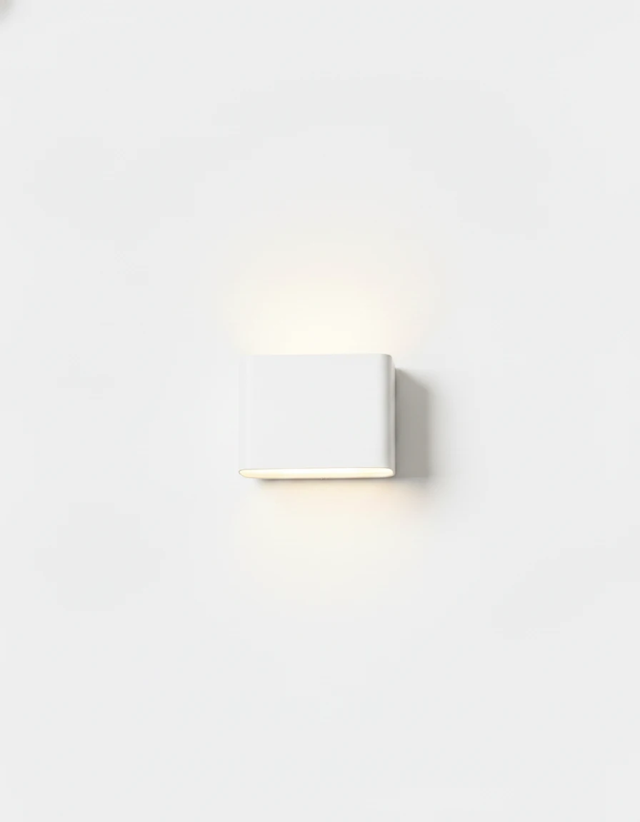 Outdoor wall sconce PISA No.01 small size in matte white, lit with a soft glow above and below on a white wall
