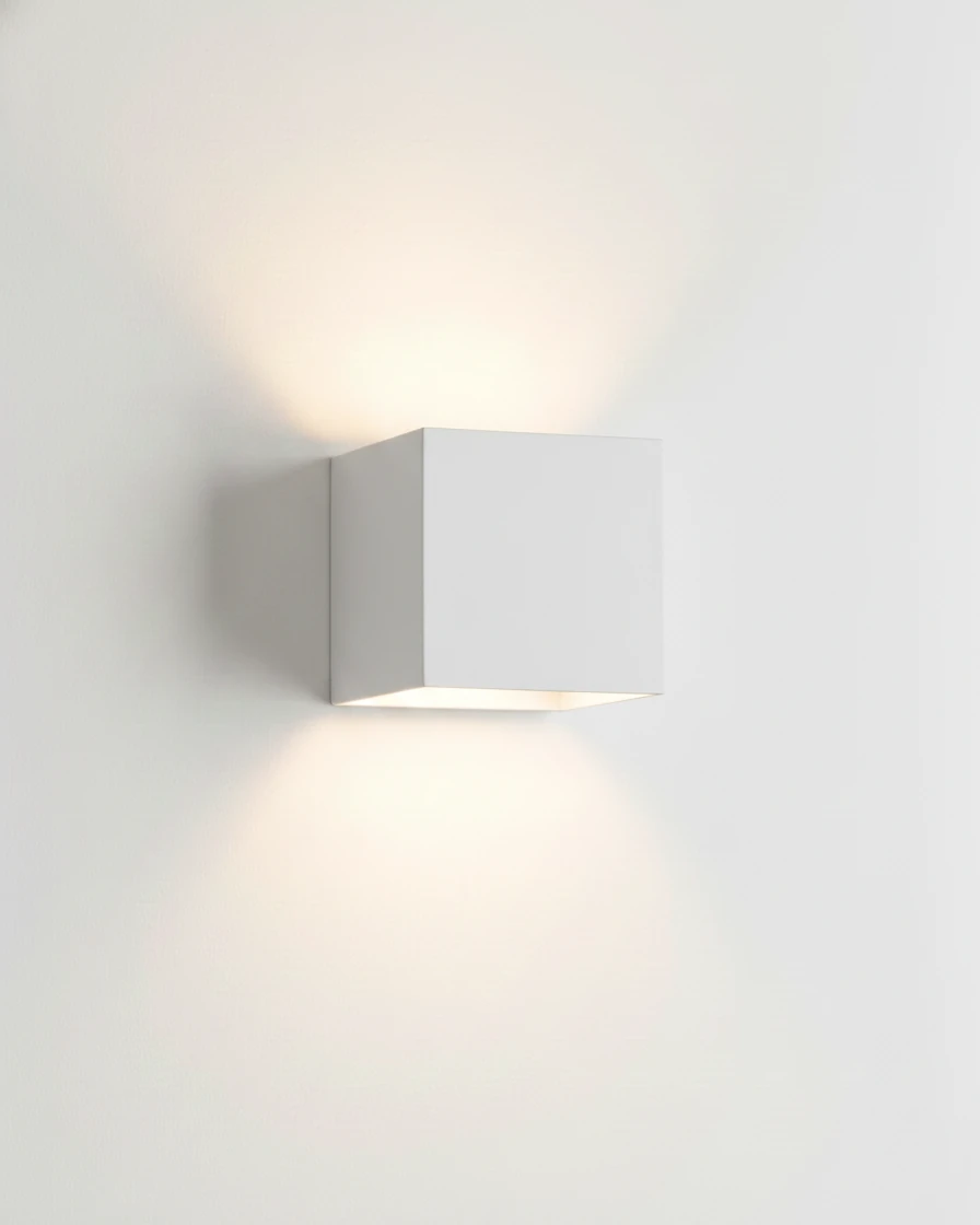 Outdoor wall sconce FARA No.01 in pure white, up-down cube lit against a plain white wall