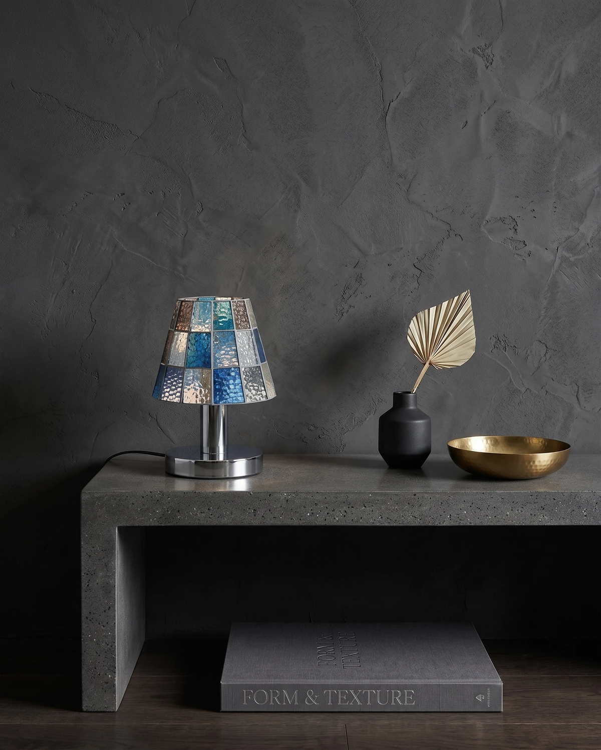 Stained glass table lamp VETRA No.01 in cobalt blue, lit on a stone console with a vase and a brass bowl