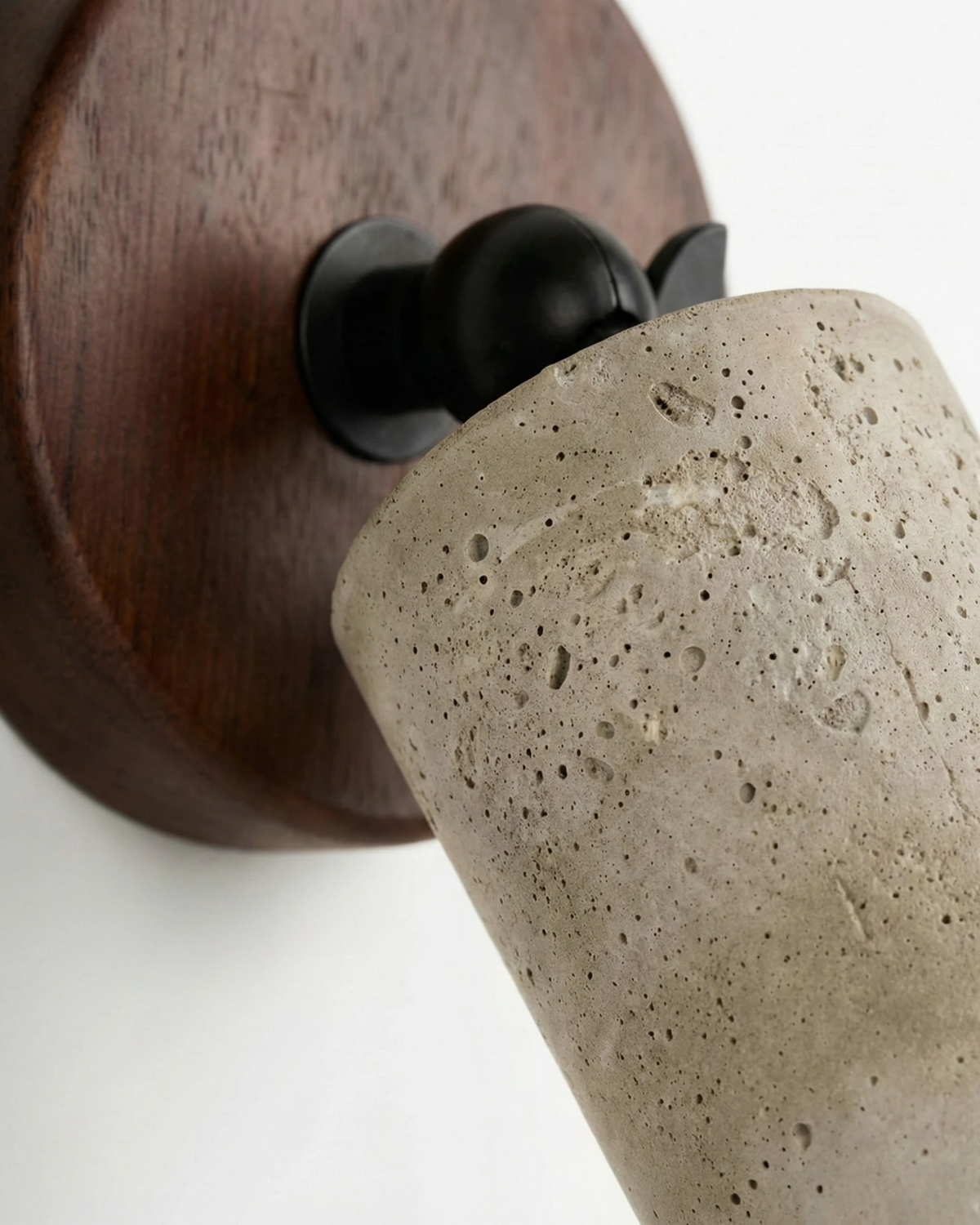 Close-up of the MANTOVA No.01 stone-effect wall sconce, stone-effect cylinder pivoting on a dark walnut backplate