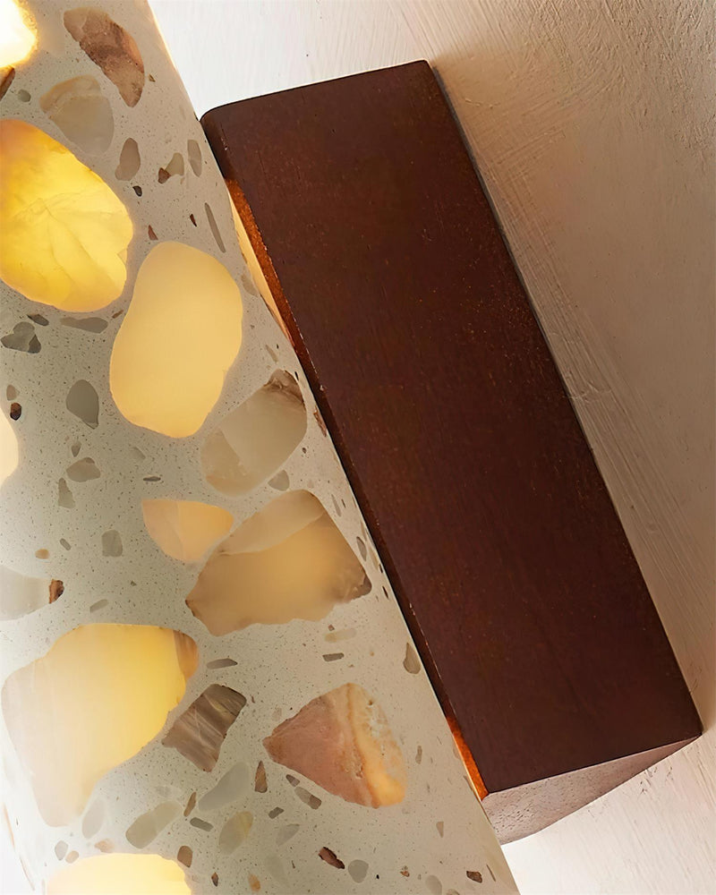 Close-up of the walnut block and glowing terrazzo cylinder of the terrazzo wall sconce INCA No.02