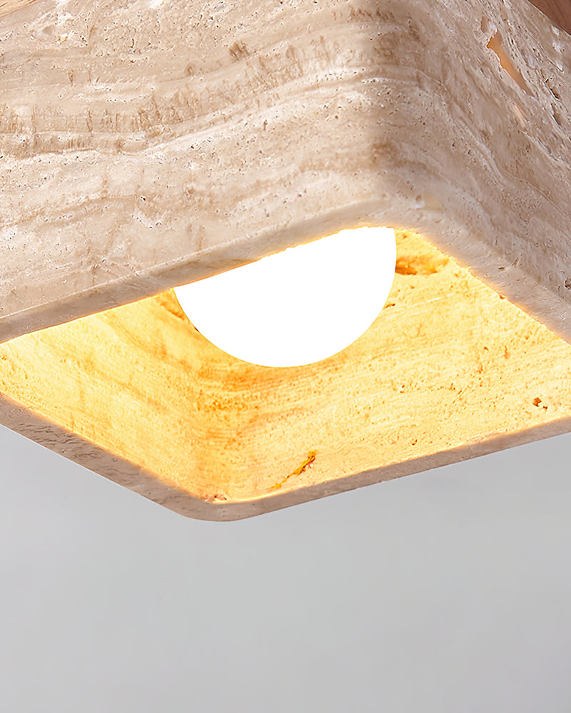 Close-up of the travertine flush mount ceiling light CARSO No.01 lit, warm light glowing through the stone opening