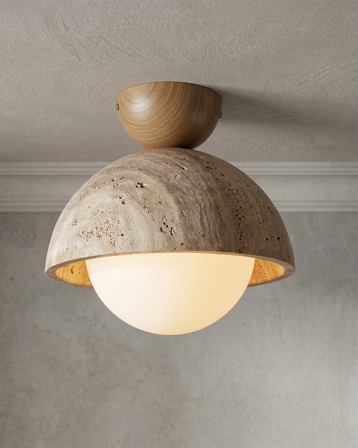 Close-up of the travertine flush mount ceiling light LUNA No.06, veined dome with a light oak canopy and a lit globe
