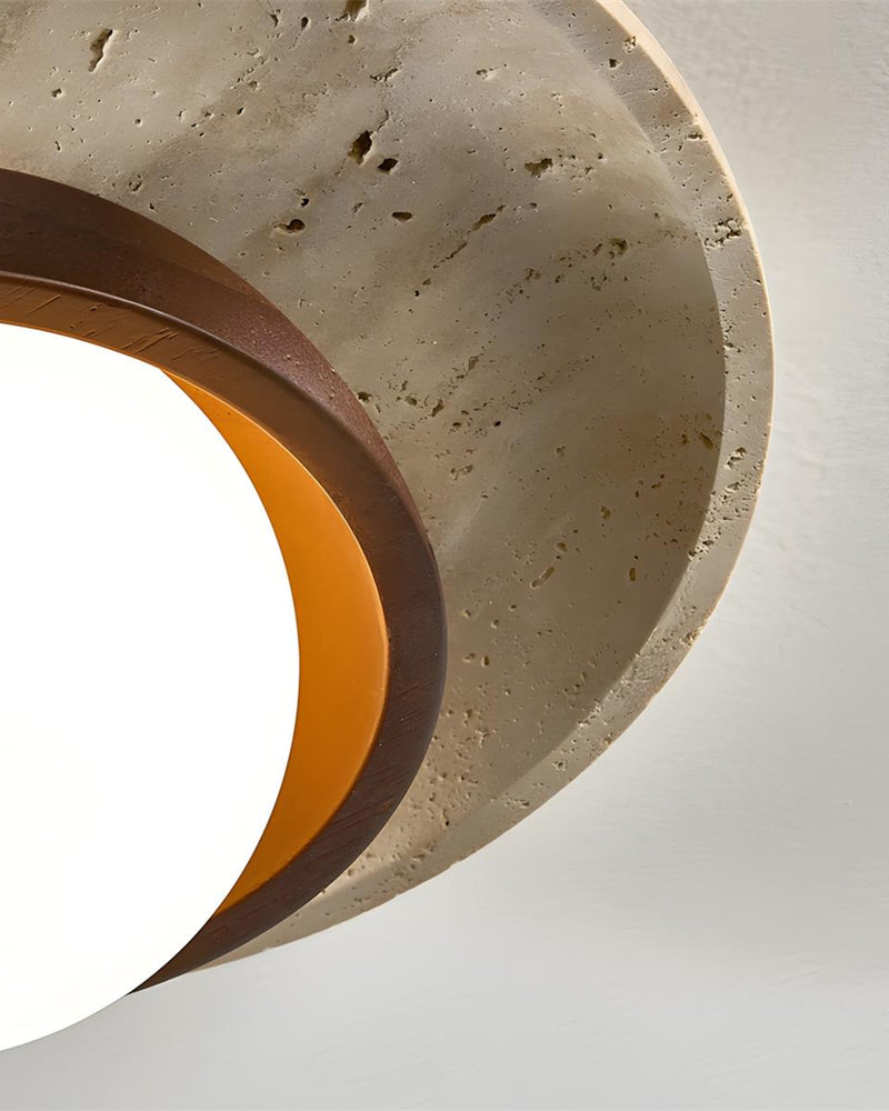 Close-up of the pitted travertine rim of the LUNA No.03 flush mount ceiling light with a warm glow beneath