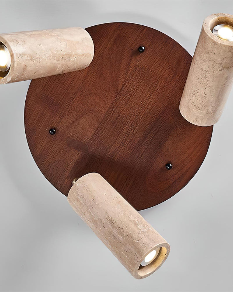 Close-up from below of the RAGGI No.02 travertine flush mount ceiling light, three spots on a walnut disc, lit