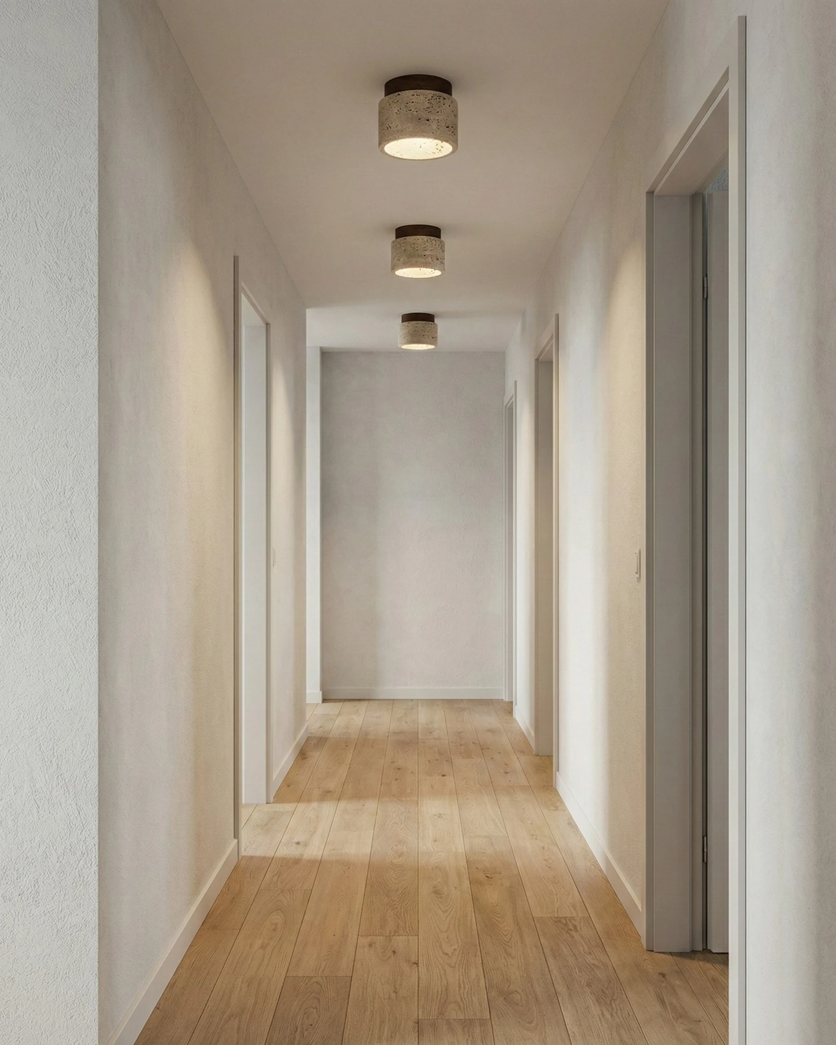 Travertine flush mount ceiling lights VERTIN No.05, three cream units lit along a narrow hallway with oak flooring