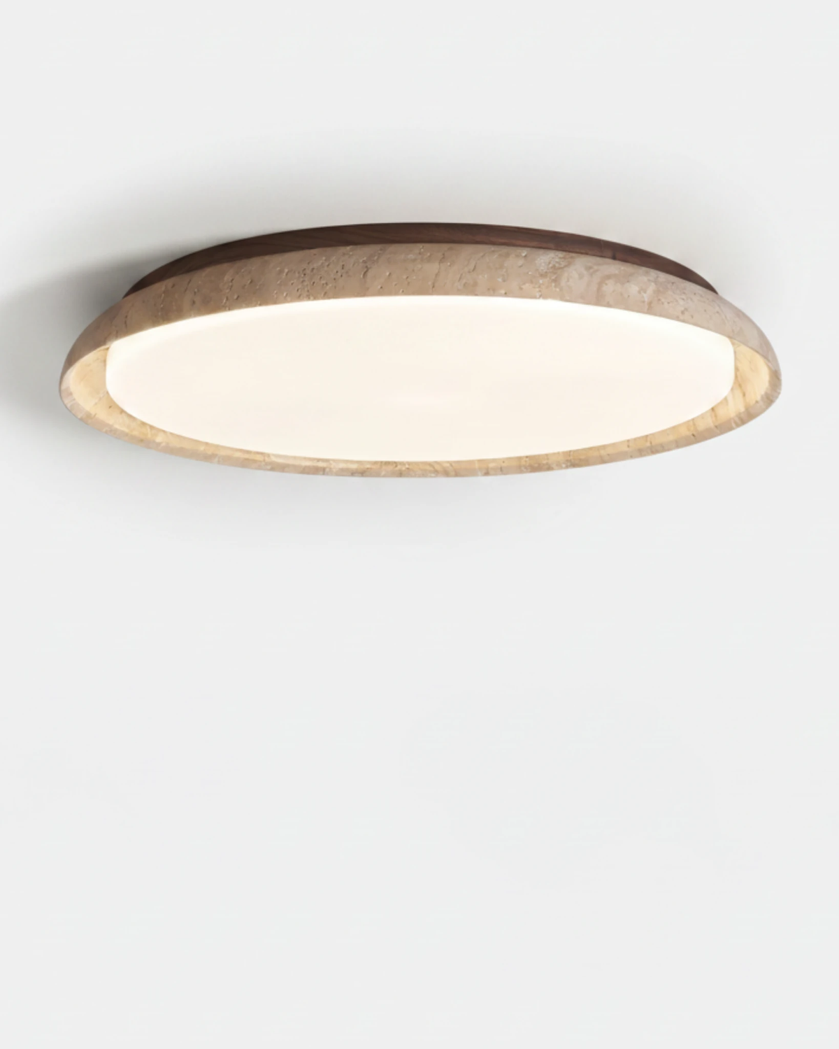Travertine flush mount ceiling light LUNA No.01 in the large 55 cm size, flat travertine disc switched on, angled view