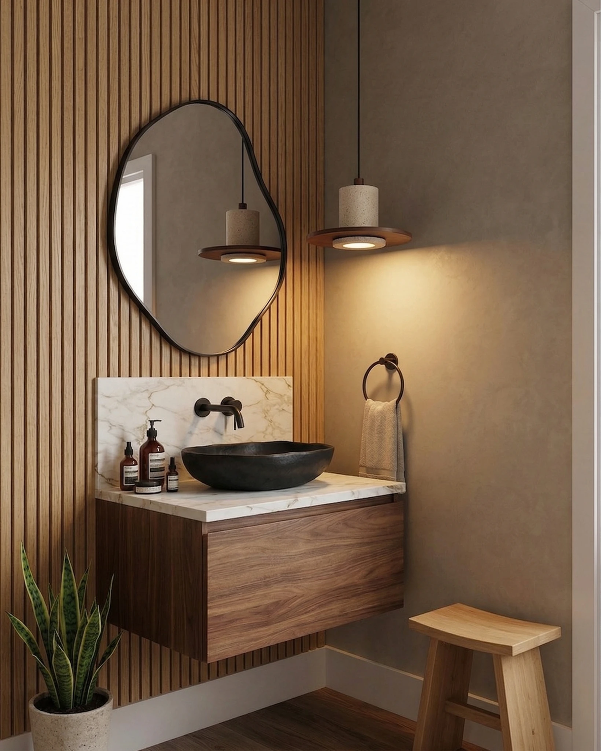 Travertine pendant light TONDO No.04 lit beside an organic mirror above a floating walnut vanity with a black basin