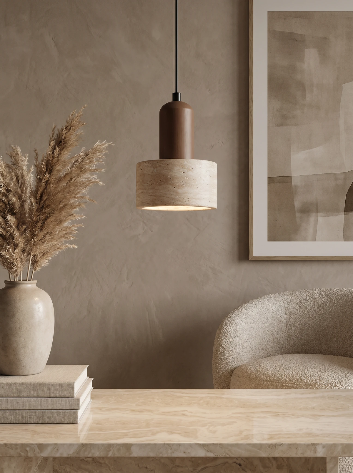Travertine pendant light TONDO No.05 lit above a stone console with pampas grass, books and a boucle chair
