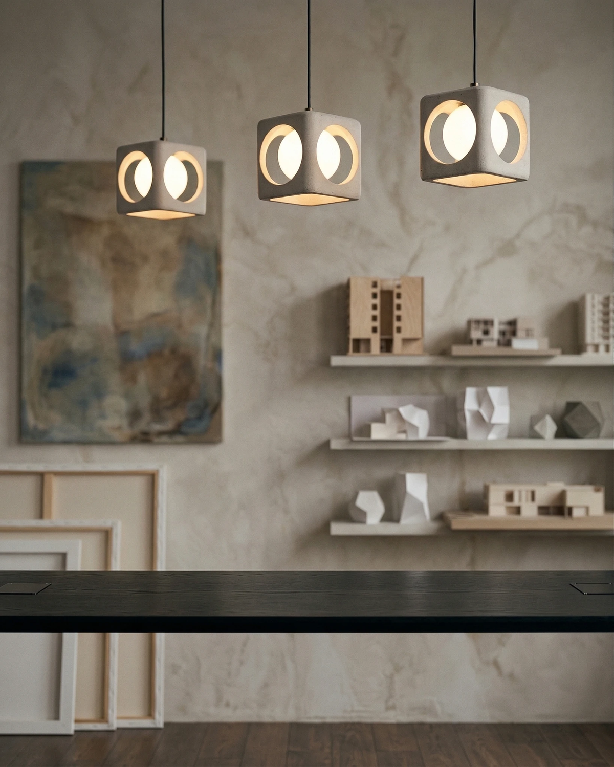 Three travertine pendant lights CUBA No.02 lit in a row above a dark counter with shelves of small objects