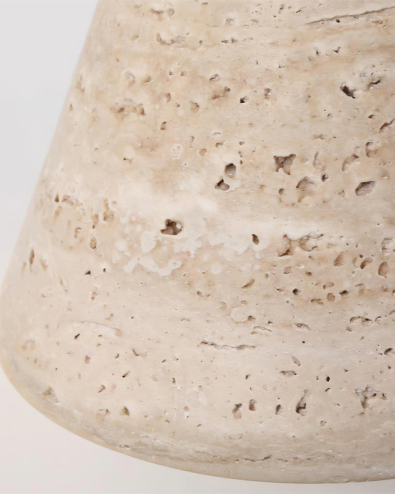 Close-up of the pitted cream travertine cone shade of the CONA No.02 pendant light showing its natural pores