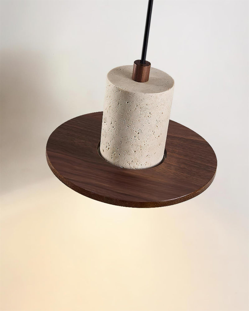 Close-up of the travertine drum and walnut saucer of the TONDO No.04 pendant light seen from above, warm light below