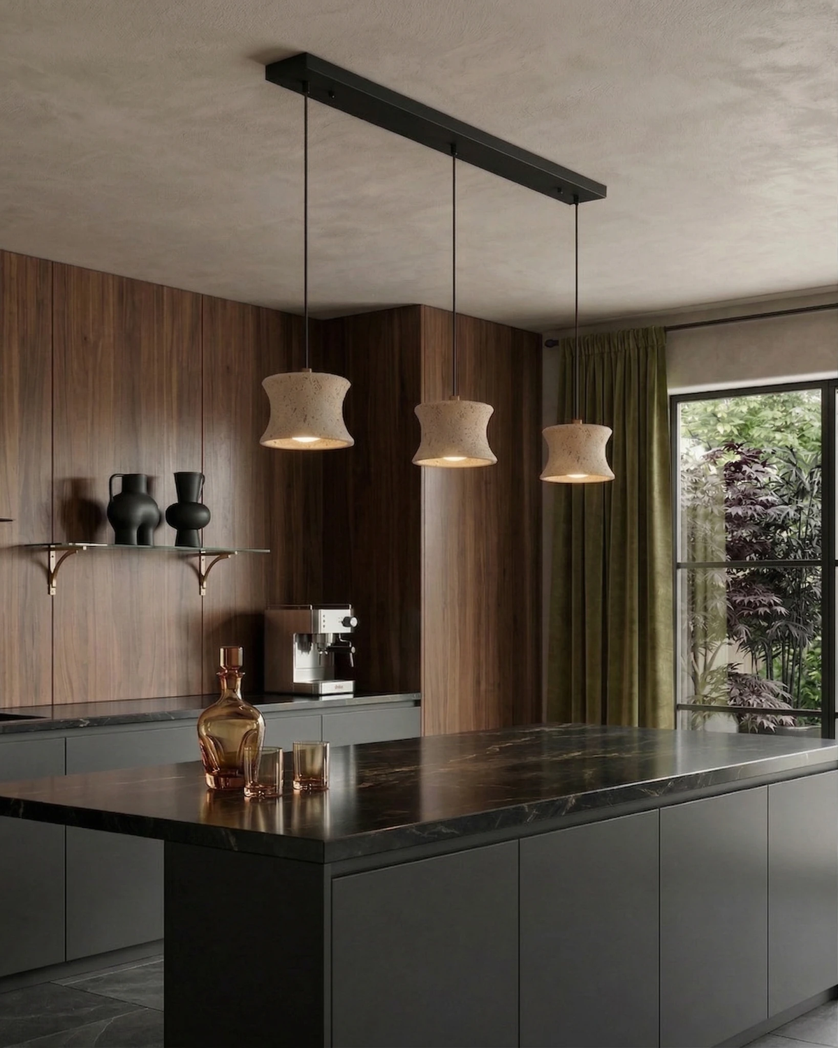 Travertine pendant light CONA No.04 Linear Three lit on a black bar above a dark kitchen island with walnut cabinets