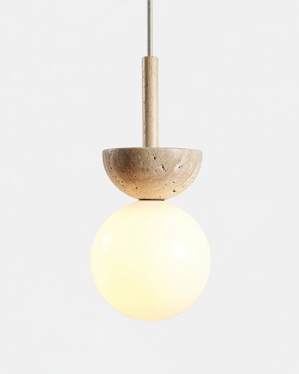 Travertine pendant light SOVA No.04 with natural wood stem, travertine dome over a lit opal globe