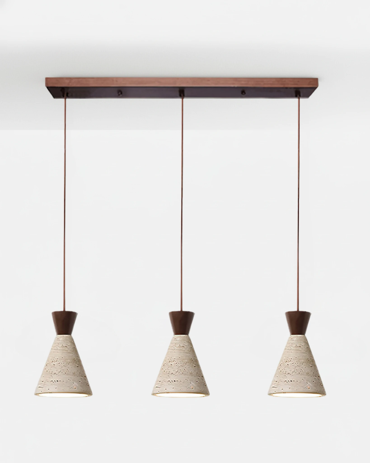 Three travertine pendant lights CONA No.02 Triple Linear in Walnut, cone shades hung in a row from a dark walnut bar