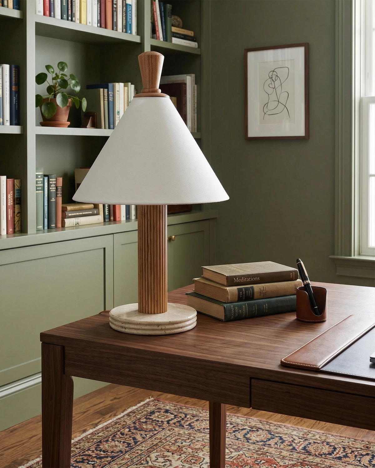 Travertine table lamp IMOLA No.01 in walnut on a wood desk with books in front of green library shelves