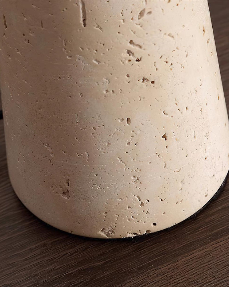 Close-up of the tapered travertine base of the travertine table lamp MORA No.02 on a dark wood surface
