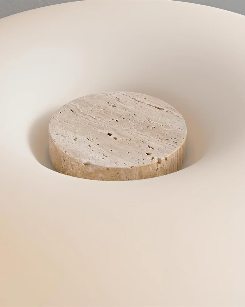 Close-up of the travertine disc set into the top of the matte glass dome of the MORA No.03 travertine table lamp