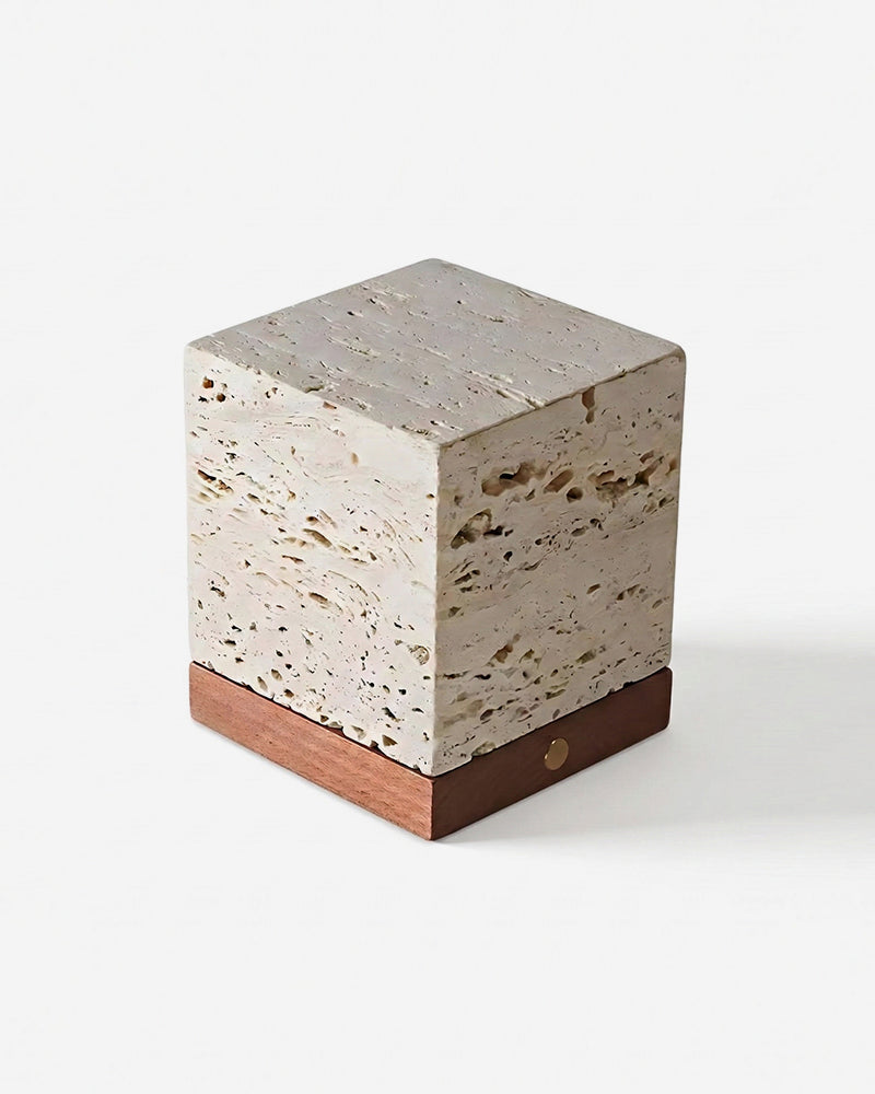 Travertine table lamp MORA No.05 unlit, pitted cream travertine cube over a walnut base with a brass button