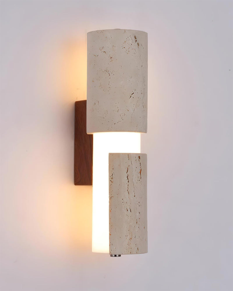 Close-up of the NOTTI No.01 travertine vanity light, lit opal tube between travertine blocks on a walnut mount