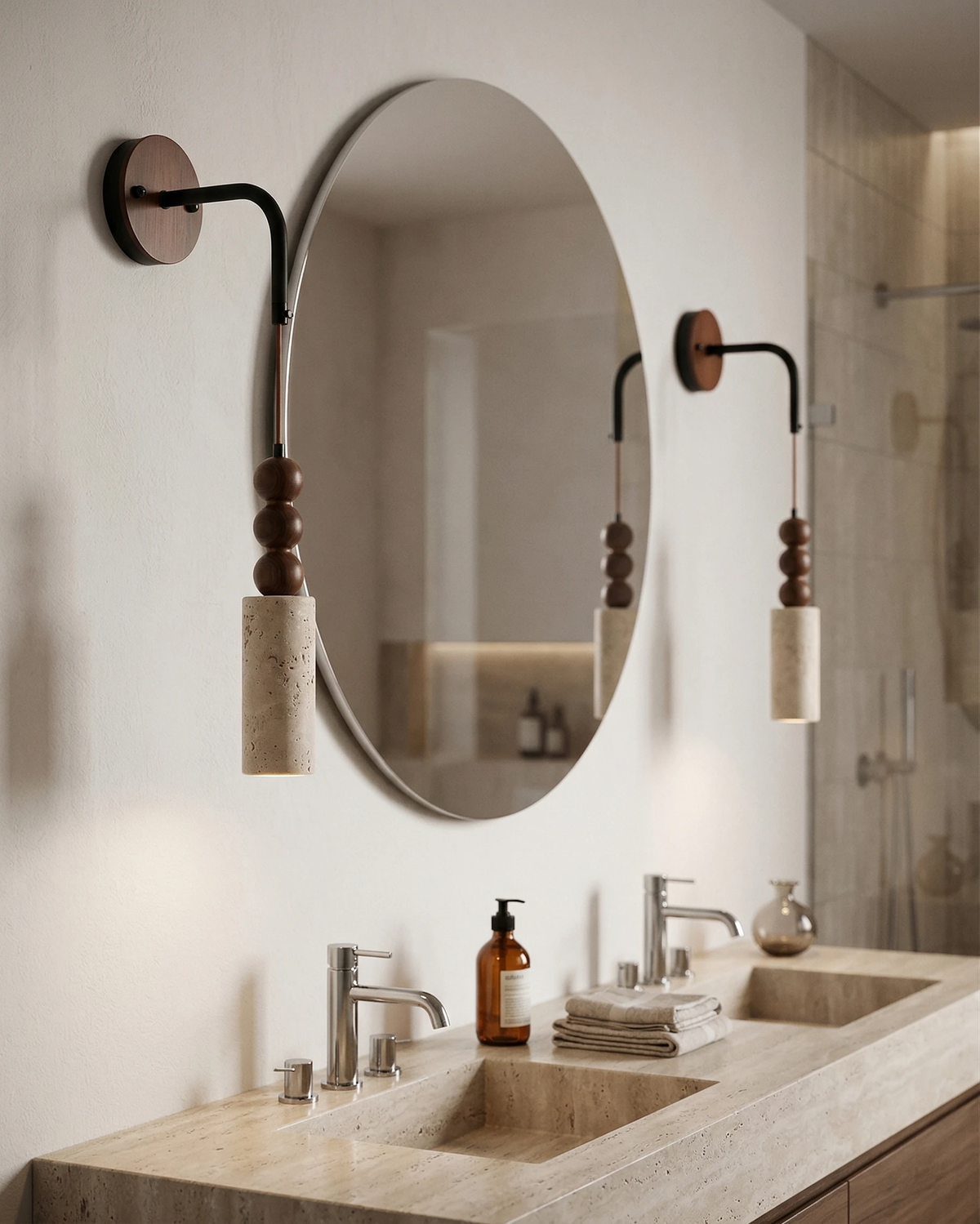 Travertine wall sconce ARGO No.01, two Perle bead pendants flanking an oval mirror above a travertine double sink