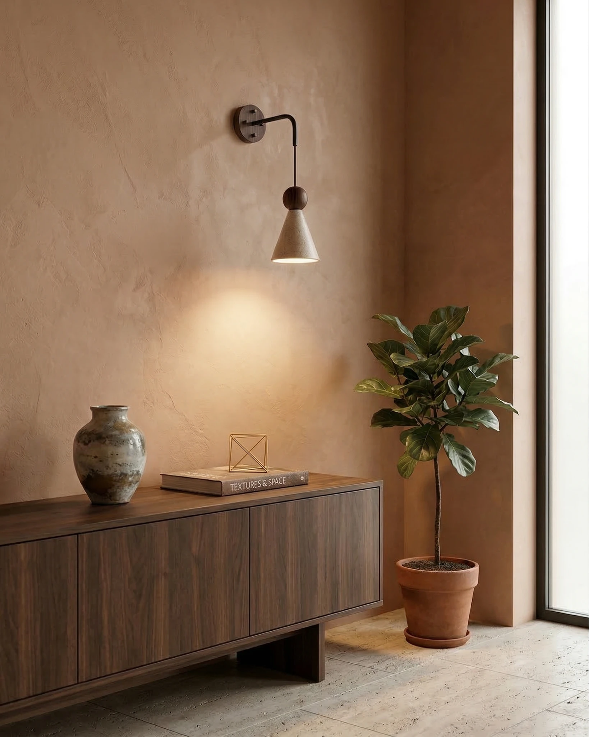 Travertine wall sconce CORTO No.01 switched on above a walnut cabinet with a vase and a potted fig by the window