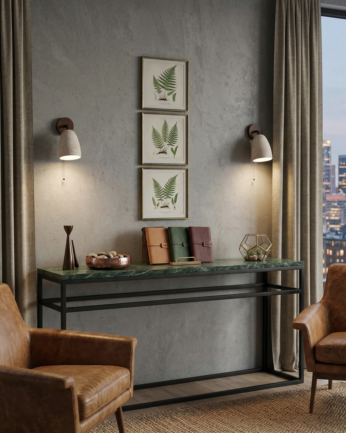 Two travertine wall sconces PERA No.01 lit above a green marble console with botanical prints and leather chairs