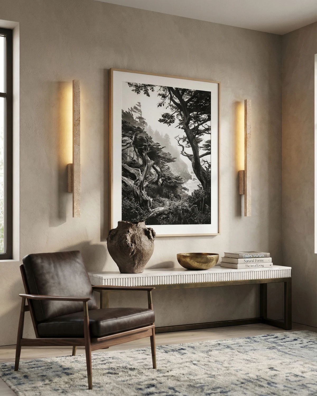 Two travertine wall sconces VITRU No.02 lit on both sides of a large framed photo above a console bench and leather chair
