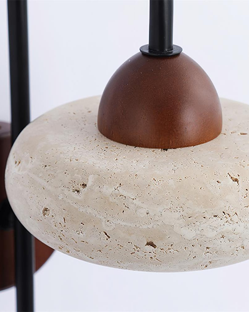 Close-up of the travertine ring and walnut dome cap of the BASSO No.01 wall sconce on its black arm