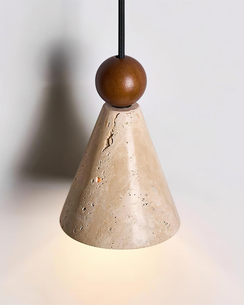 Close-up of the CORTO No.01 travertine wall sconce cone and walnut ball on its dark rod, switched on