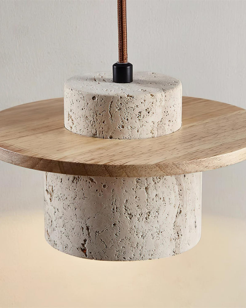 Close-up from below of the oak disc and pitted travertine cylinder of the TIVOLI No.01 travertine wall sconce, glowing