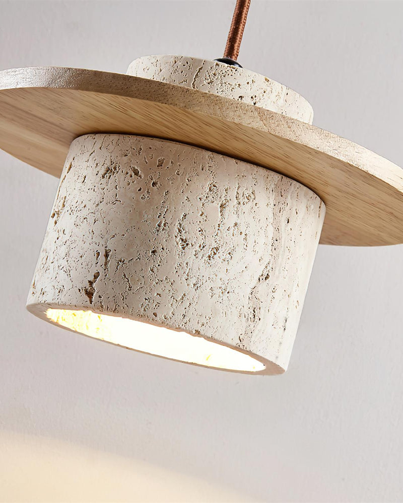 Angled close-up of the TIVOLI No.01 travertine wall sconce shade, lit interior visible under the oak disc