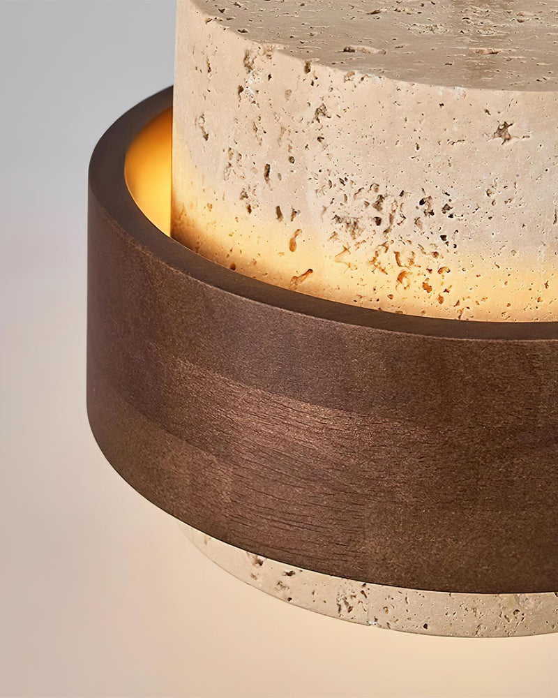 Close-up of the travertine drum and walnut belt of the travertine wall sconce TIVOLI No.02 glowing from within