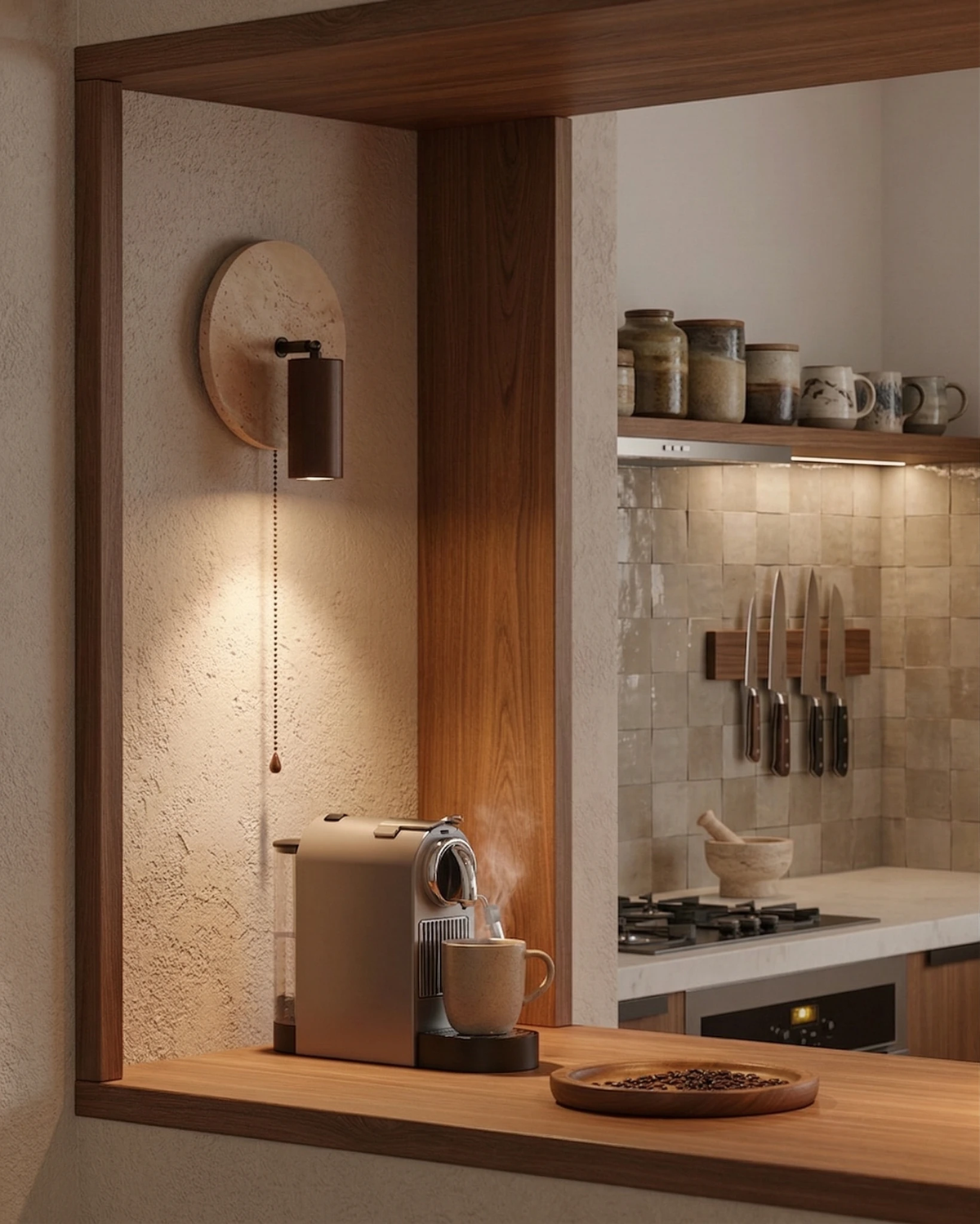 Travertine wall sconce VITRU No.03 switched on beside a walnut-framed pass-through into a kitchen with an espresso machine