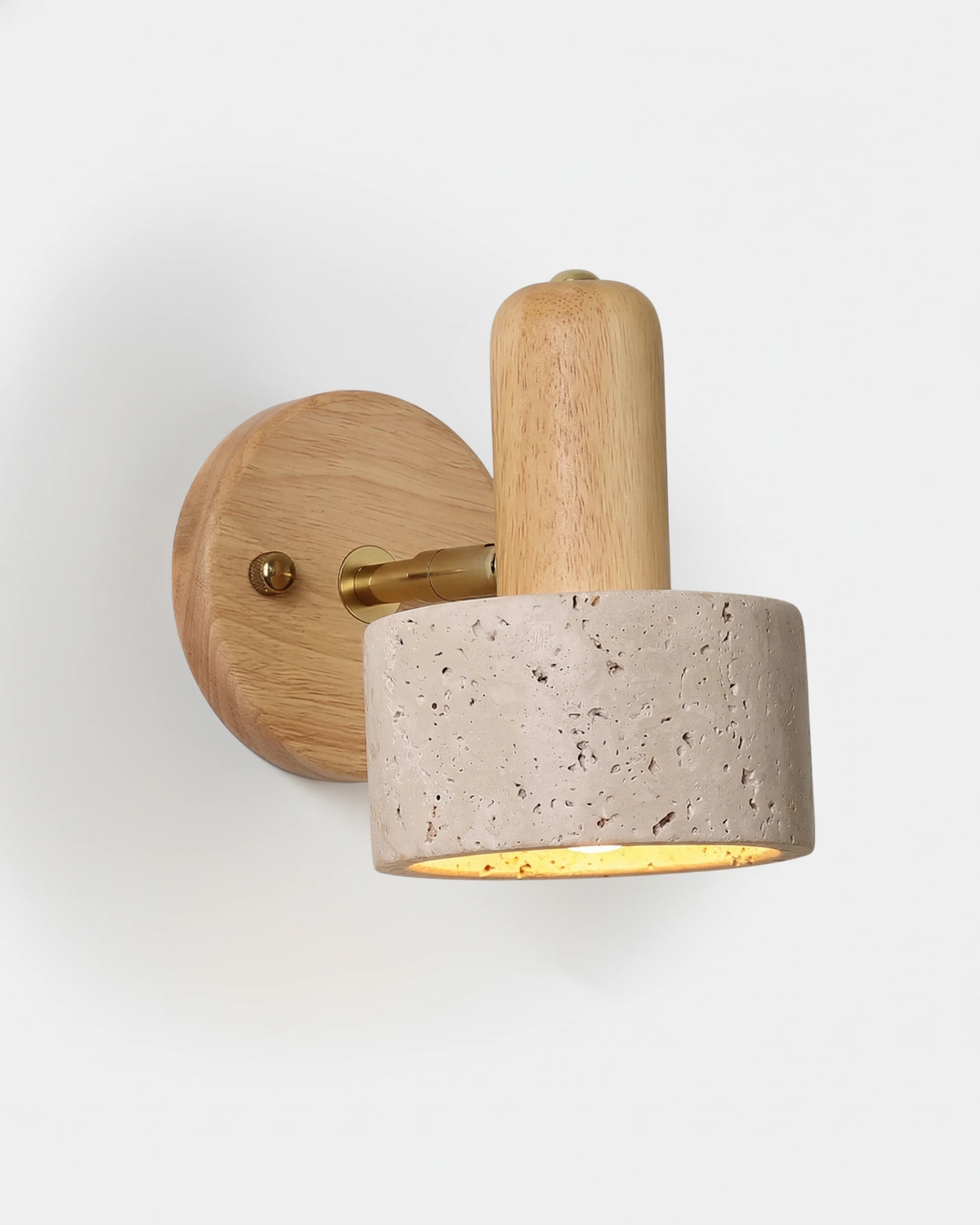 Travertine wall sconce CONA No.01, stone-only cylinder head on a light oak backplate with brass arm, lit
