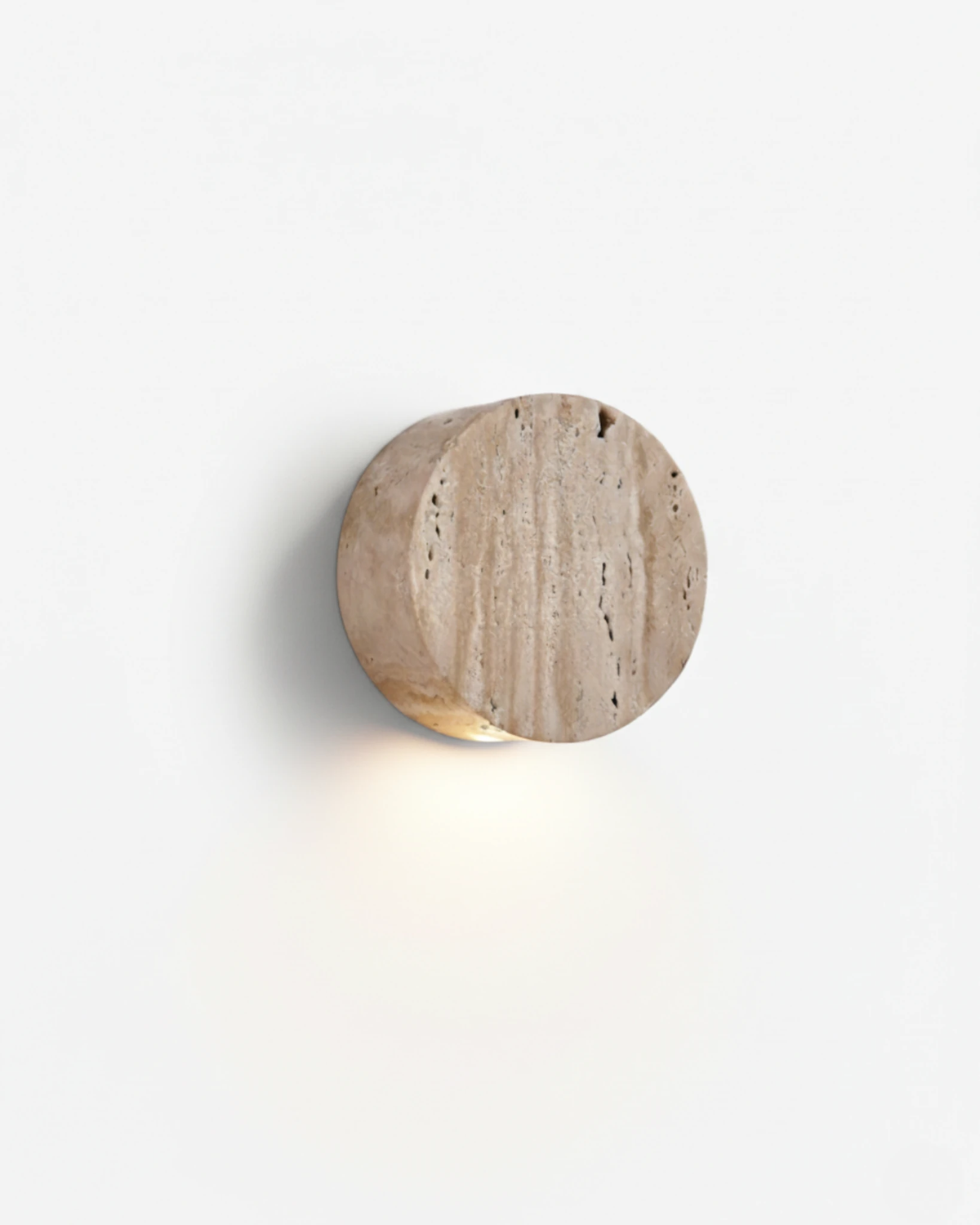 Travertine wall sconce VERONA No.01, circular yellow travertine disc casting a downward glow on a white wall