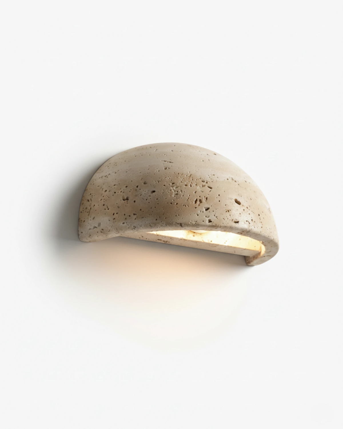 Travertine wall sconce BERGAMO No.01 in Yellow Travertine, pitted stone half-dome with light glowing from below