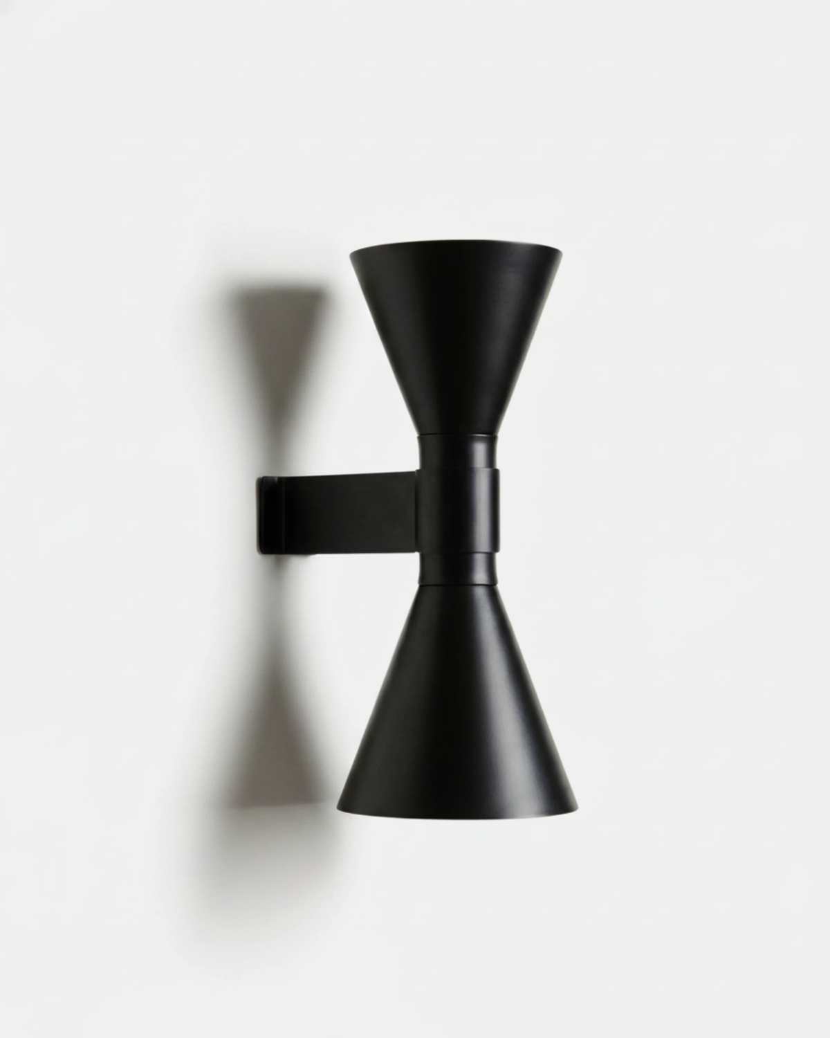 Up down wall sconce ECLISSI No.01 in Matte Black, two opposed aluminum cones on a short arm, unlit