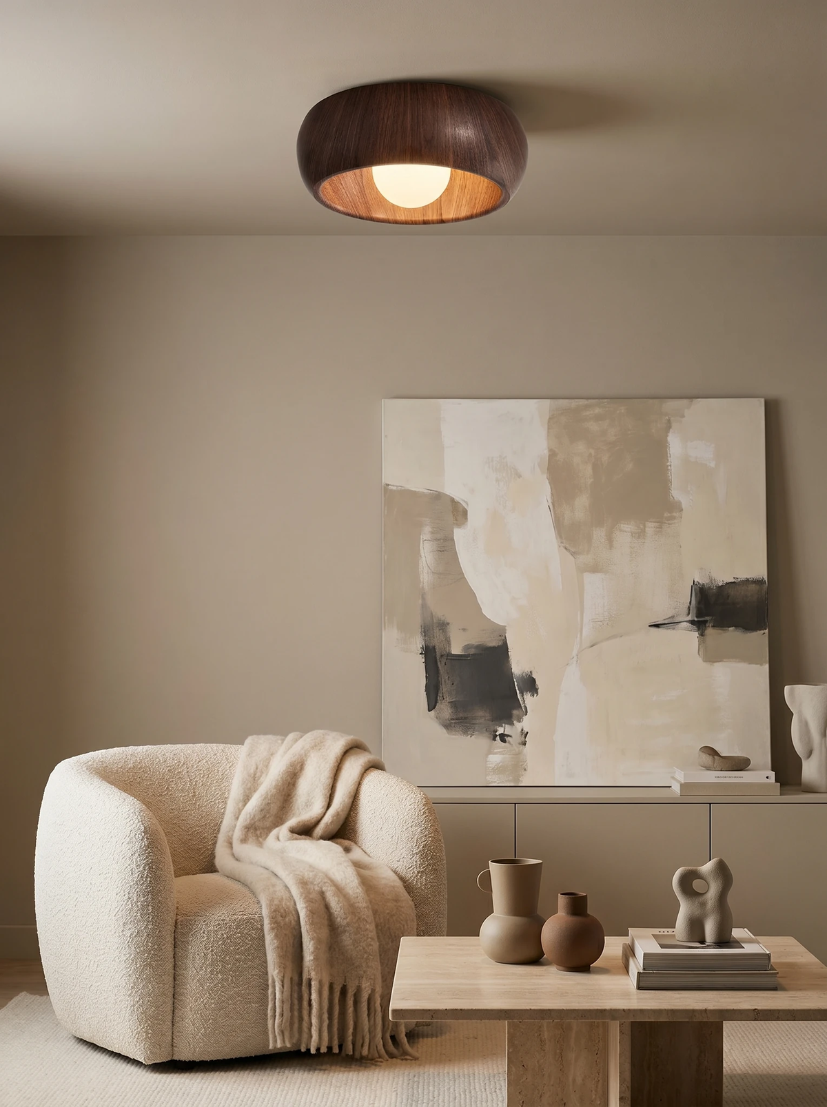 Wood flush mount ceiling light OMBRA No.01 in dark walnut lit above a boucle armchair in a beige living room
