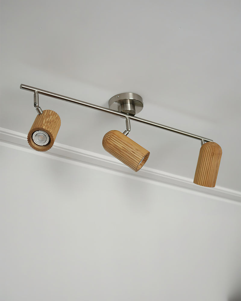 Wood flush mount ceiling light RIGA No.06 seen from below, three fluted wood spots angled on a nickel bar