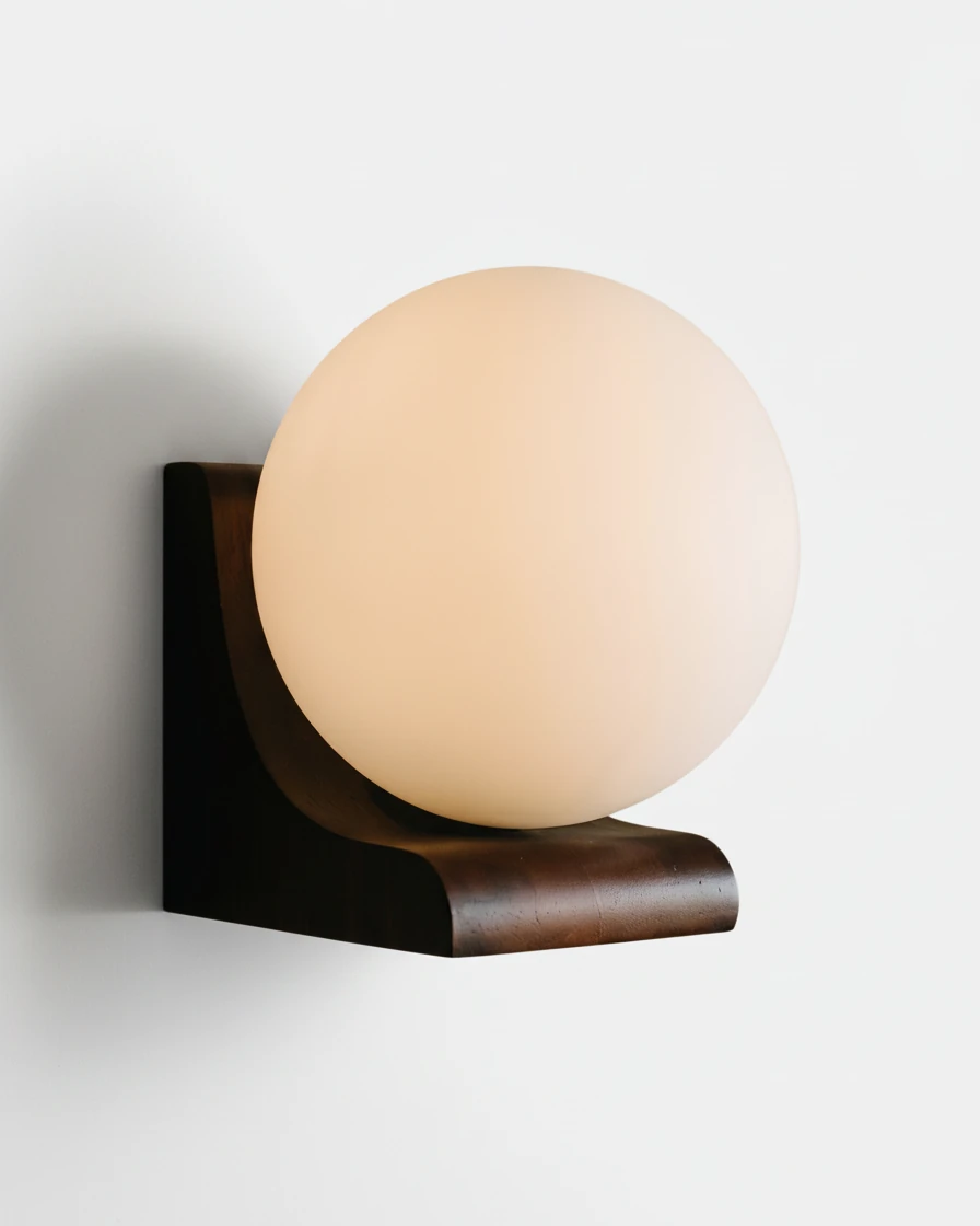 Wood wall sconce CURVA No.01 in Dark Walnut with Frosted Glass, bent wood bracket and a warmly lit globe