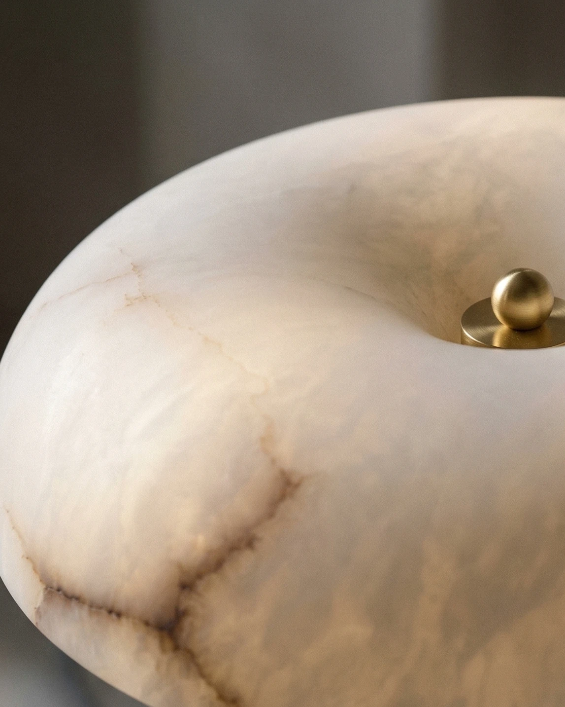 Close-up of the glowing alabaster top with a small brass finial on the alabaster table lamp OBSI No.01