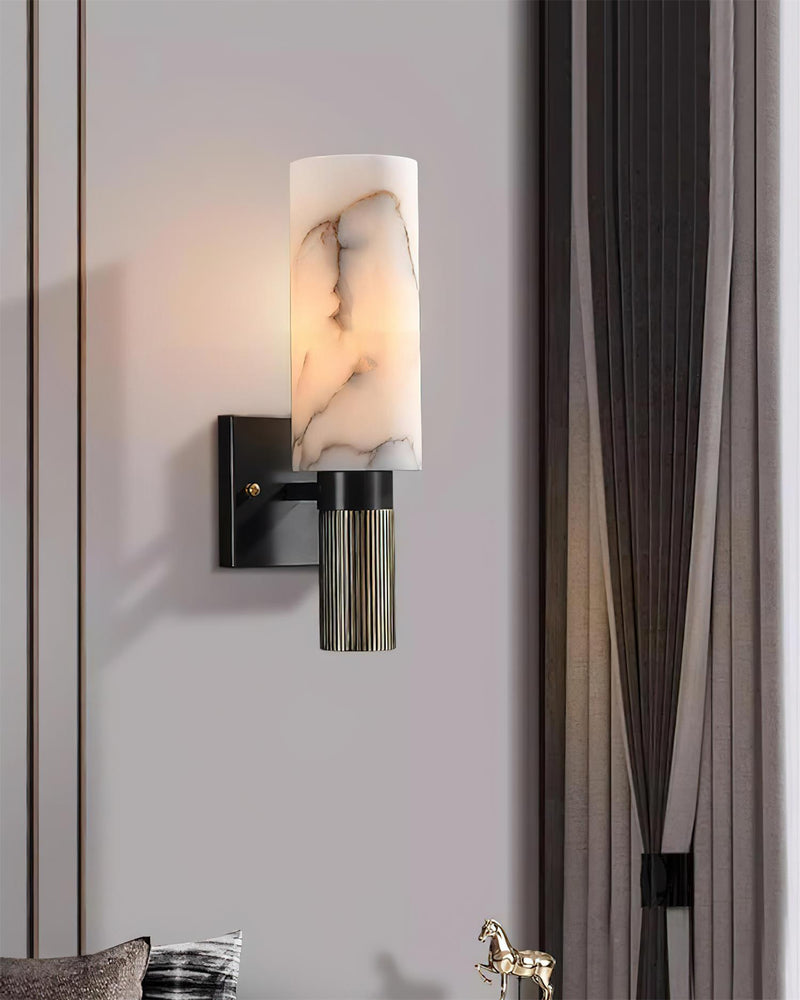 Alabaster wall sconce ALABA No.07 switched on against a mauve wall beside a gray curtain and a brass horse figurine