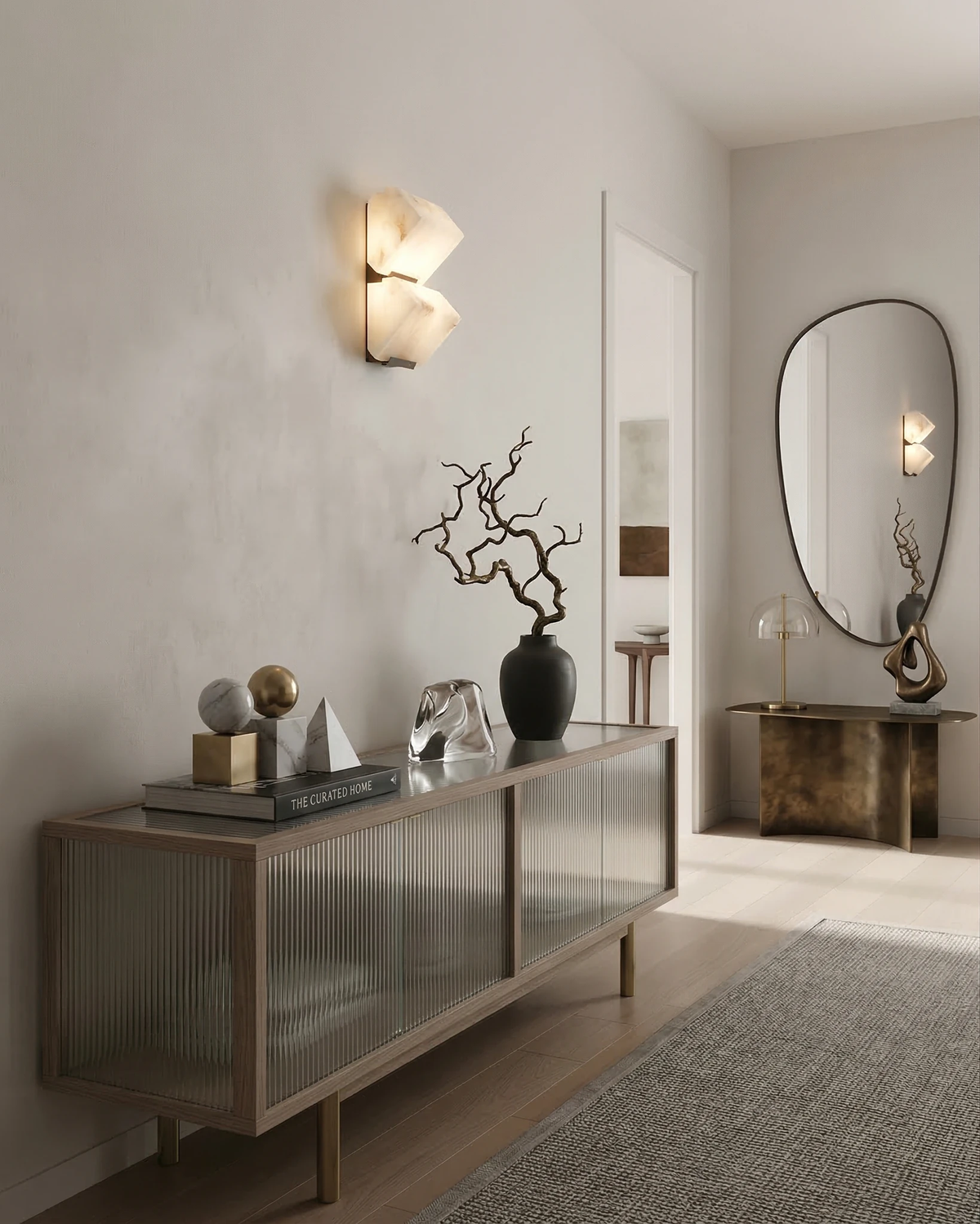 Alabaster wall sconce ALABA No.05 duo lit above a glass-fronted sideboard with a curved mirror and ornaments