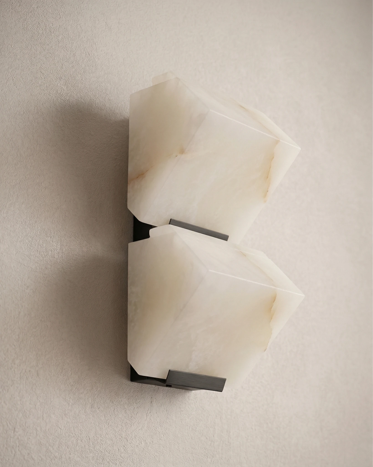 Close-up of the ALABA No.05 alabaster wall sconce duo, unlit, side view showing the black brackets
