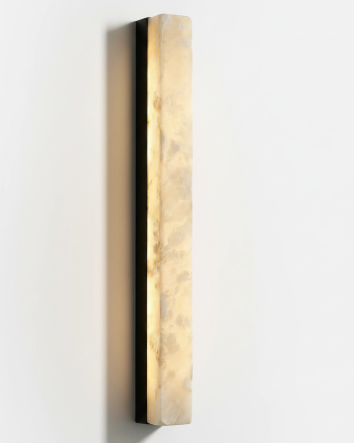 Alabaster wall sconce NEBBIA No.02, 40 in column on a Volcano Black bar, switched on, front view on white