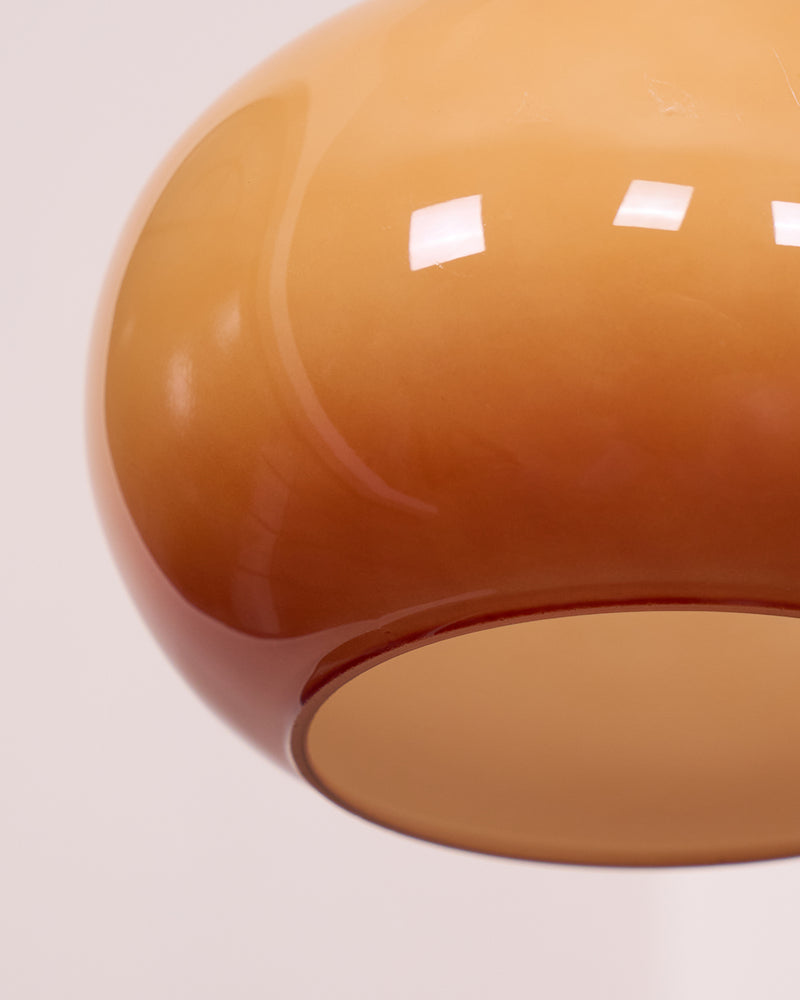 Close-up of the glossy amber dome glass of the OVIA No.04 pendant showing its open bottom rim