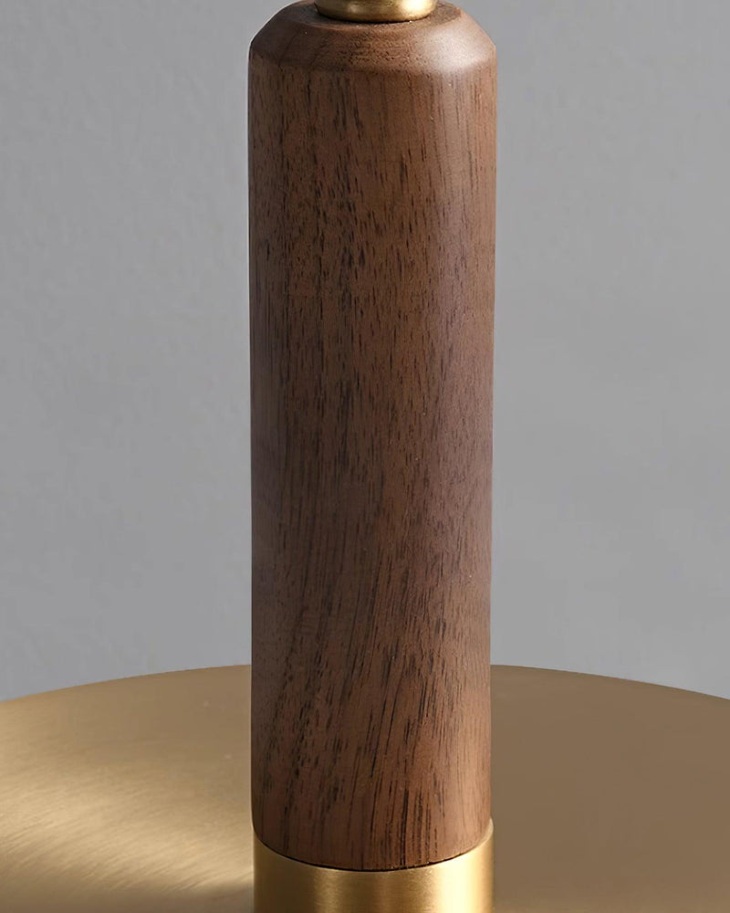 Close-up of the walnut stem of the amber glass table lamp TARO No.02 meeting its brushed brass base