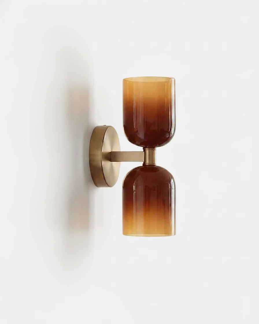 Brass wall sconce ALDO No.01 with twin caramel glass cups on a brushed gold bracket, unlit on a white wall