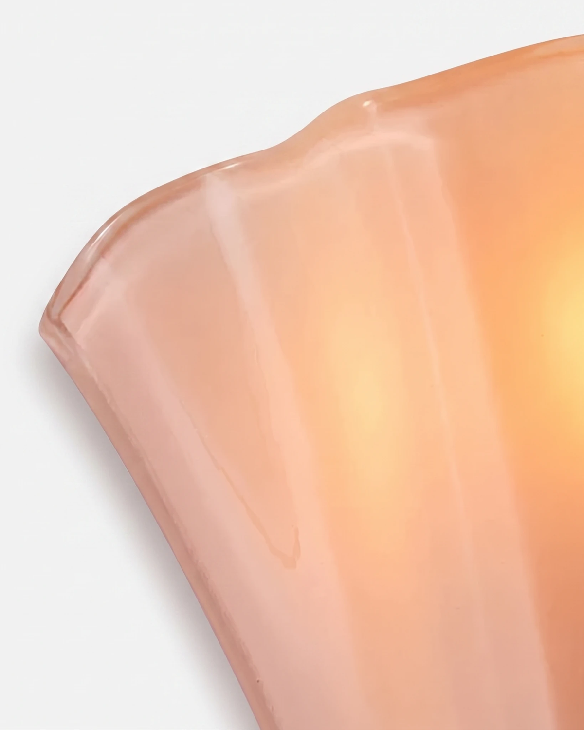 Close-up of the soft rose glass rim of the brass wall sconce DALIA No.03 with its folded petal shape